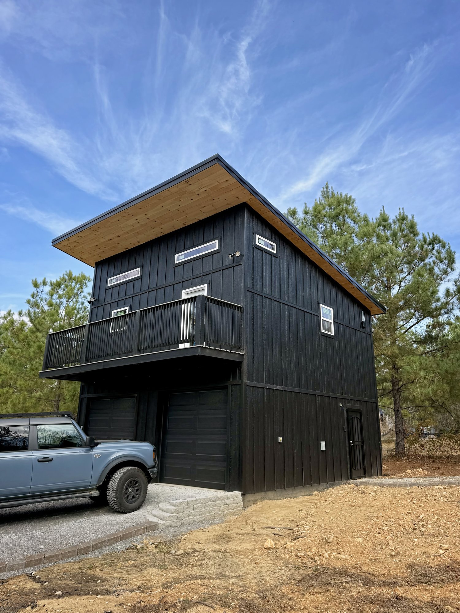 Two-story black skillion-roof garage