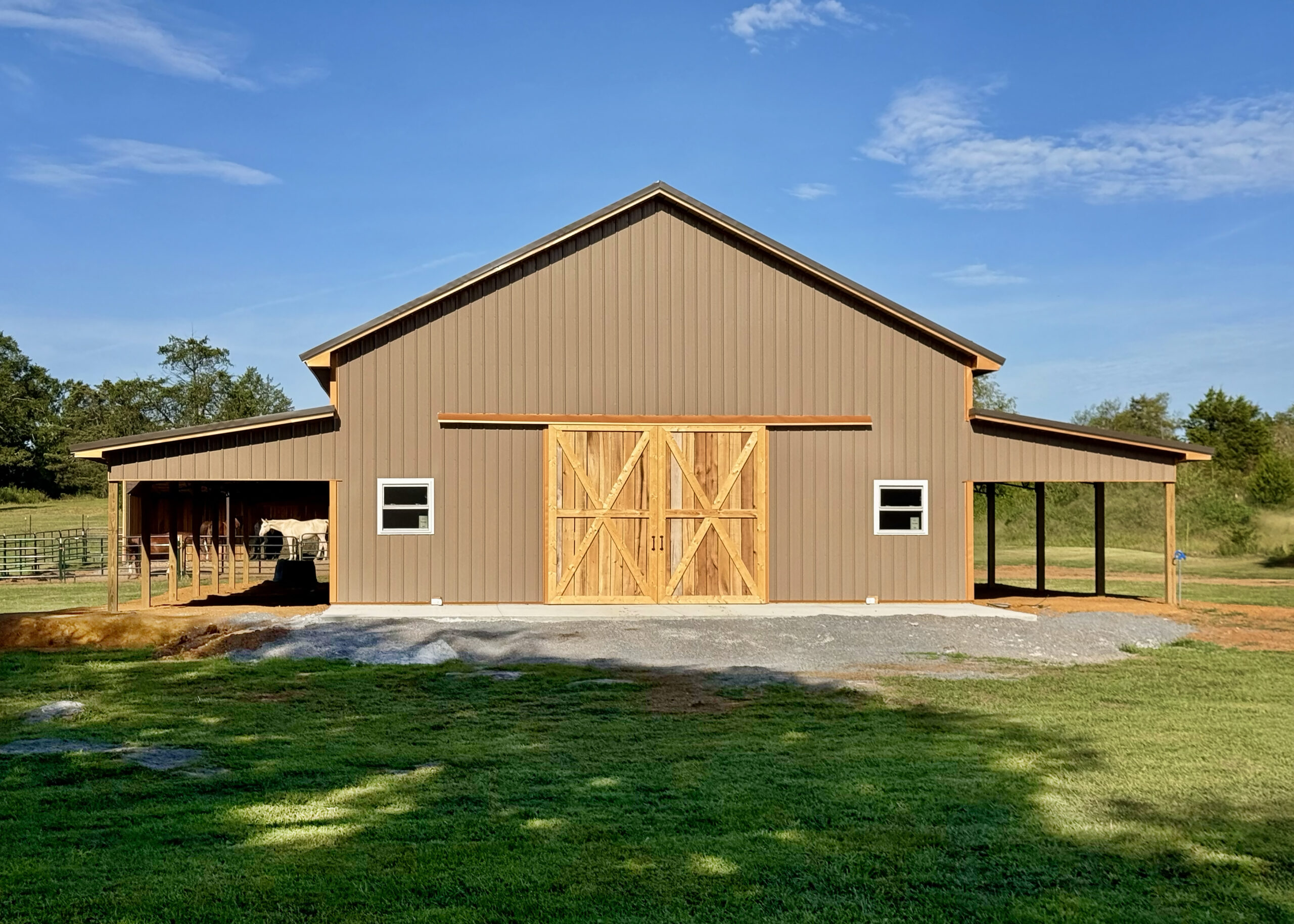 Brown pole barn with horses