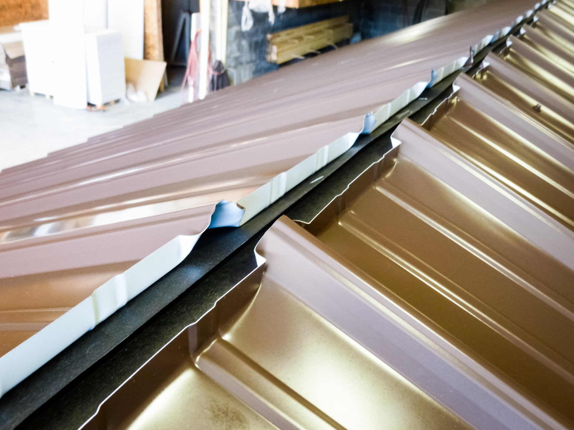 Close-up of an Esh's shed's metal roof seam and ridge cap during construction