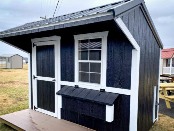 A small chicken house for sale in Kentucky with black and white siding