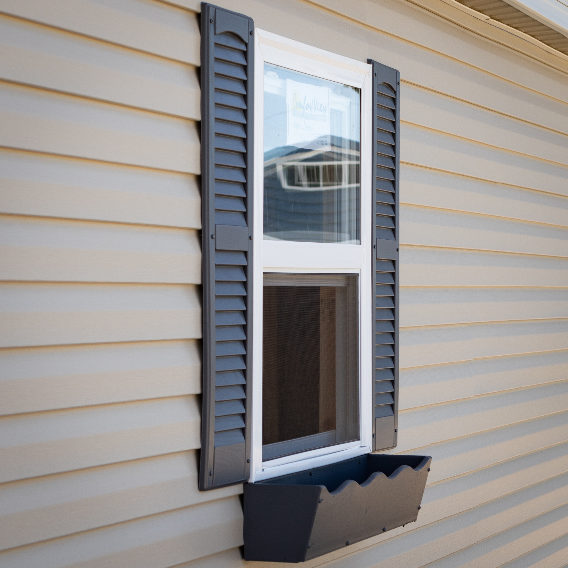 A window with shutters and flowerbox on a custom shed in Kentucky or Tennessee