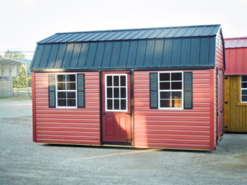 A vinyl storage building in Tennessee with red siding and two windows with shutters