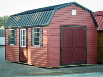 A barn-style storage building in Tennessee with red vinyl siding and double doors