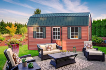 A lofted storage building in Tennessee with vinyl siding and two windows with shutters