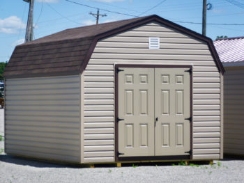 A storage building in Tennessee with vinyl siding and a brown shingle roof