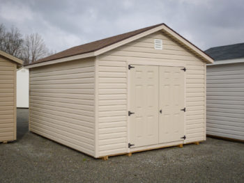 A shed in Kentucky with vinyl siding, double doors, and a shingle roof