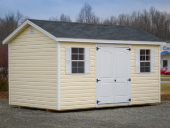 A shed in Kentucky with vinyl siding, windows with shutters, and a shingle roof