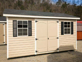 A vinyl shed with double doors, windows, and shutters