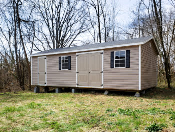 A vinyl shed in Kentucky with double doors, windows, and shutters