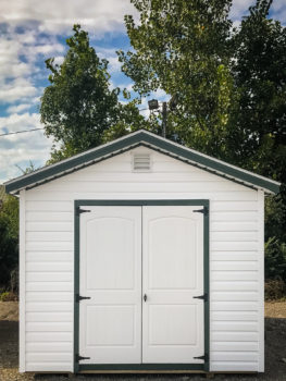 A shed in Tennessee with white vinyl siding and double doors