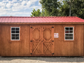 A discounted shed in Tennessee with wooden siding and a red metal roof