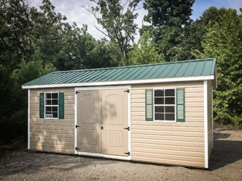 A shed in Tennessee with vinyl siding and a green metal roof