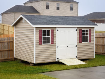 A shed in Tennessee with vinyl siding, double doors, and windows with shutters