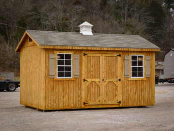 A shed in Tennessee with wooden siding and a shingle roof with a cupola