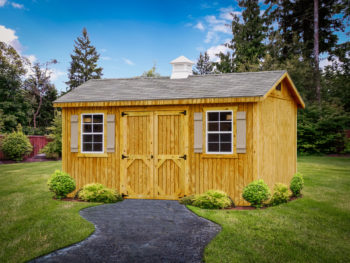 A wooden shed in Tennessee with double doors, windows, and shutters