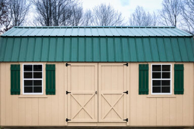 A portable building in Kentucky with painted wood siding and a green metal roof