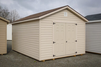 A shed in Kentucky with vinyl siding, double doors, and a shingle roof