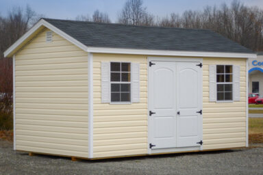 A shed in Kentucky with vinyl siding, windows with shutters, and a shingle roof