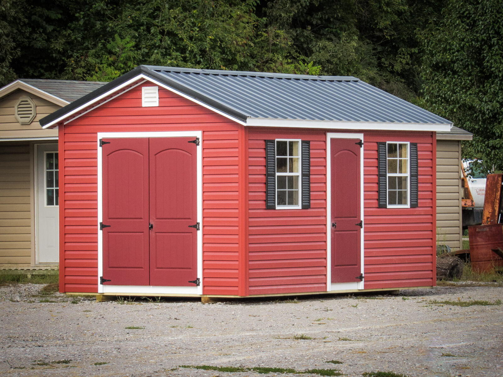 A shed in Tennessee with red vinyl siding and a metal roof