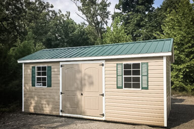 A garden shed in Tennessee with vinyl siding, double doors, and a green metal roof