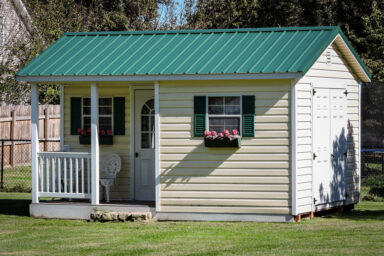 A prefab cabin in Tennessee with vinyl siding and a green metal roof