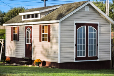 A prefab cabin in Tennessee with vinyl siding, double doors, and a roof dormer