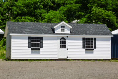 A prefab cabin in Tennessee with vinyl siding and two windows with flower boxes