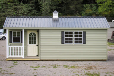 A prefab cabin in Tennessee with vinyl siding and metal roof with a cupola