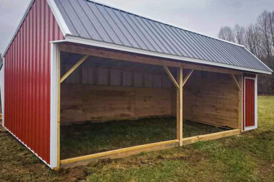 A metal horse run-in shed sold in Kentucky with wooden kickboards