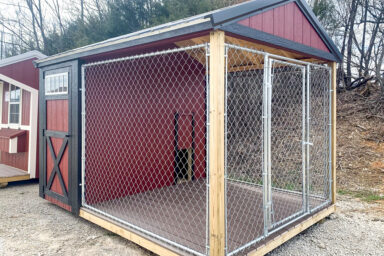 A red and black outdoor dog kennel for sale in Kentucky with wooden siding