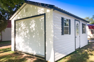 A small portable garage in Tennessee with white vinyl siding and two windows