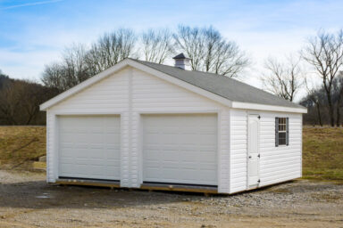 A multiple-car prebuilt garage in Kentucky with white vinyl siding and a cupola