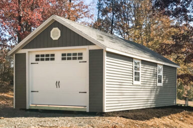 A single-car garage shed in Tennessee with green vinyl siding and windows