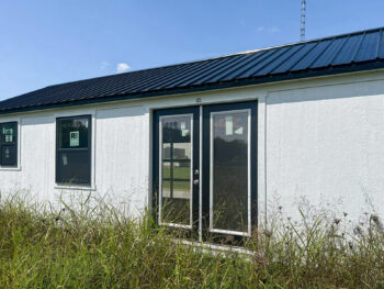 white ranch tiny house shells with dormer and black metal roof